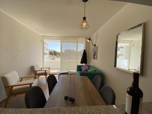 拉塞雷纳La Serena Apartment的客厅配有桌子和一瓶葡萄酒