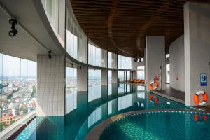 a swimming pool in a building with a view of a city at Mandala Hotel & Suites Hải Dương in Bảo Thap