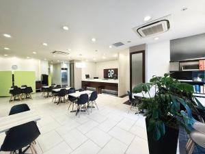 a restaurant with tables and chairs in a room at Green Rich Hotel Iwakuni Ekimae (Artificial hot spring Futamata Yunohana) in Iwakuni