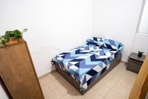 - une chambre avec un lit doté d'une couette bleue et blanche dans l'établissement La Esquinita de Miraflores, à Medellín