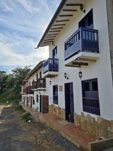 una casa bianca con balconi blu di IL CASTELLO DI LETTERE Barichara a Barichara