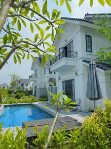 a villa with a swimming pool in front of a house at Biệt thự Đế Liên nguyên căn 2 tầng- Vườn Vua Resort Phú Thọ in Ðồng Phú