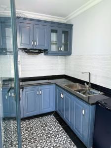 a kitchen with blue cabinets and a sink at Biệt thự Đế Liên nguyên căn 2 tầng- Vườn Vua Resort Phú Thọ in Ðồng Phú +18 photos