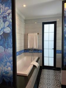 a bathroom with a tub and a painting on the wall at Biệt thự Đế Liên nguyên căn 2 tầng- Vườn Vua Resort Phú Thọ in Ðồng Phú