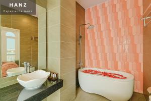 a bathroom with a bath tub and a sink at S79 Hotel T68 in Ho Chi Minh City