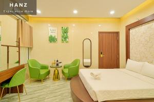 a hotel room with a bed and two green chairs at S79 Hotel T68 in Ho Chi Minh City +1 photo