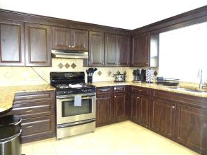 a kitchen with wooden cabinets and a stove at Comfortable Renovated 3 Bed Apartment in Framingham