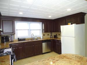 a kitchen with wooden cabinets and a white refrigerator at Comfortable Renovated 3 Bed Apartment in Framingham