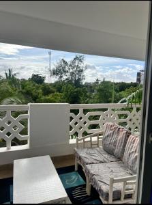 a balcony with a couch and a table and a window at Sunrise Apartments in Nyali