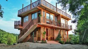 una casa con un balcón encima en 2 Bedoom Loft, Kitchen, Garden, en Mazunte