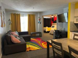 a living room with a couch and a colorful rug at Whimsical Condo 1.5M from Disney in Orlando