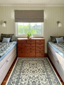 1 dormitorio con 2 camas, vestidor y ventana en Sjøutsikt Og Skogsro På Rødtangen, en Berger