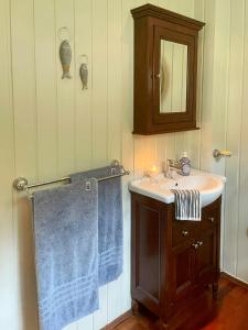 baño con lavabo y toalla azul en Sjøutsikt Og Skogsro På Rødtangen, en Berger