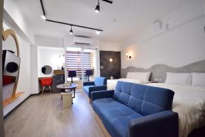 a hotel room with a bed and a blue couch at Zhiben Wu Jiari in Wenquan