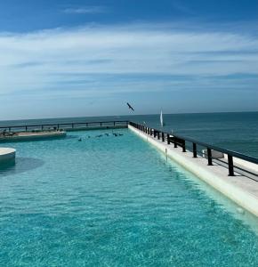 a group of people swimming in a pool near the ocean at Progreso Luxury Oceanfront Condo at Yucalpetén Resort Marina in Progreso