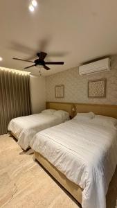 two beds in a bedroom with a ceiling fan at Progreso Luxury Oceanfront Condo at Yucalpetén Resort Marina in Progreso +15 photos