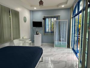 a bedroom with a bed and a table and a tv at NAPA CHATEAU Resort in Ban San Khu