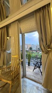 a room with a window with a chair on a balcony at Rox Luxury Hotel - روكس الفاخرة in Taif