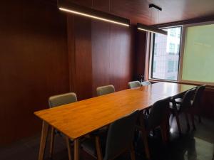 a conference room with a wooden table and chairs at Hongdae Main Street Unique Interior, Spacious Room in Seoul