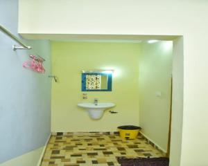 a bathroom with a sink and a toilet in a room at Bamboo world kuruva in Pulpally