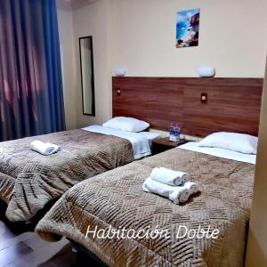 a hotel room with two beds with towels on them at Alojamiento Casca in Huaraz