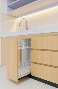 a dishwasher in a kitchen with wooden cabinets at Djuragan Kamar Dmangkoe in Bonorejo
