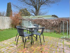einen Tisch und Stühle auf einer Backsteinterrasse in der Unterkunft Dawns Cottage in the heart of Daylesford with Fireplace in Daylesford