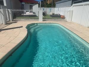 a swimming pool with blue water in a backyard at Noble House in Tathra