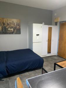 a bedroom with a blue bed and a cabinet at Central studio in Paignton