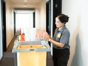 a woman standing next to a counter in a room at B2 Hat Yai Rat Uthit Boutique & Budget Hotel in Sathani Hat Yai