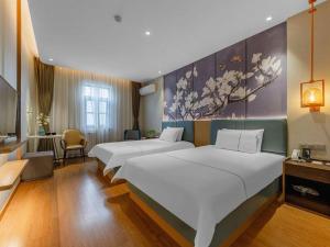 a hotel room with two beds and a room with at Magnotel Business Qufu Sankong Scenic Area Chunqiu West Road in Jining +143 photos