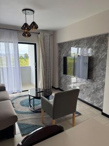 a living room with a couch and a tv on a wall at Rest & Roam in Bliss in Ballito +69 photos