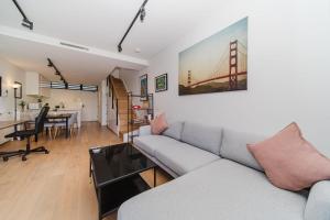 a living room with a couch and a table and a bridge painting at Cosy Urban Escape near Sydneys Top Attractions in Sydney