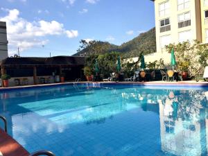 a large swimming pool in front of a building at Hotel Granja Brasil Resort in Itaipava