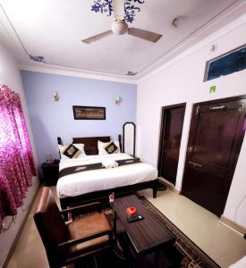 una camera da letto con un letto e un ventilatore a soffitto di Hotel Rajshree Palace a Udaipur