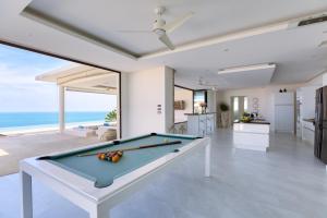 a pool table in a living room with the ocean at Villa Turquoise in Bophut 