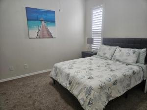 Un dormitorio con una cama y un cuadro en la pared. en Sunset Palm Stay, en San Petersburgo
