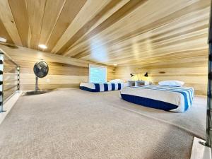 two beds in a room with wooden walls at Escalante Escapes Desert Willow- Loft Escape in Escalante