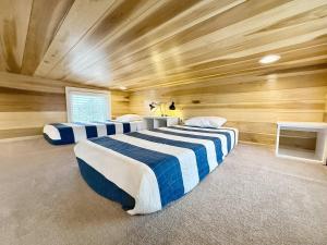 three beds in a room with wooden walls at Escalante Escapes Desert Willow- Loft Escape in Escalante