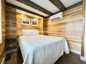 a bedroom with a bed in a room with wooden walls at Escalante Escapes Desert Willow- Loft Escape in Escalante +23 photos