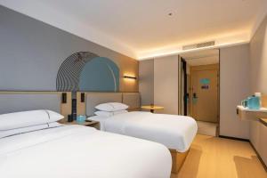 ein Hotelzimmer mit zwei Betten und einem Badezimmer in der Unterkunft City Comfort Inn Hechi Bama Shouxiang Avenue in Bama + 222 Fotos