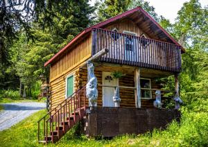 Cabaña de madera con porche y balcón en Midnight Sun Log Cabins, en Moose Pass