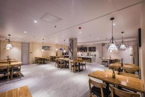 a restaurant with wooden tables and chairs in a room at City Comfort Inn Shaoguan High-speed Railway Station Xilian Examination Center in Shaoguan
