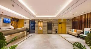 a lobby of a hotel with a woman standing in it at City Comfort Inn Shaoguan High-speed Railway Station Xilian Examination Center in Shaoguan