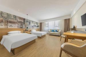 a large hotel room with two beds and a couch at City Comfort Inn Lingshui Central Avenue Bus Station in Lingshui +103 photos