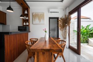 a dining room with a wooden table and chairs at Anna Villa Pererenan in Canggu