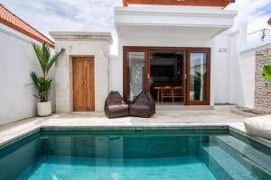a swimming pool in the backyard of a house at Anna Villa Pererenan in Canggu