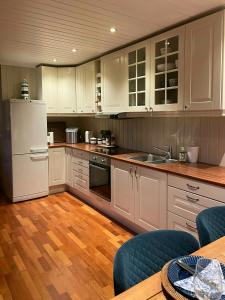 Una cocina con gabinetes blancos y un refrigerador blanco. en Sjøutsikt Og Skogsro På Rødtangen, en Berger