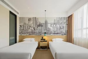 two beds in a room with a drawing on the wall at City Comfort Inn Dongguan Gaobu Avenue in Dongguan