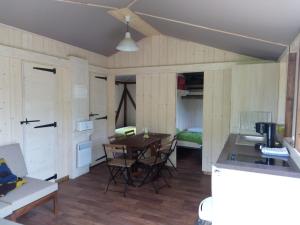 a kitchen and living room with a table and chairs at Camping Chambord in Mont-près-Chambord